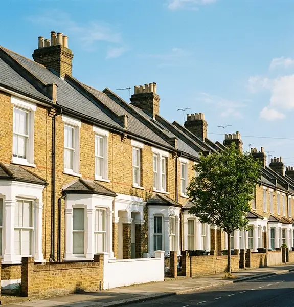 Sunlit street of Victorian terraced houses with slate roofs and chimney stacks